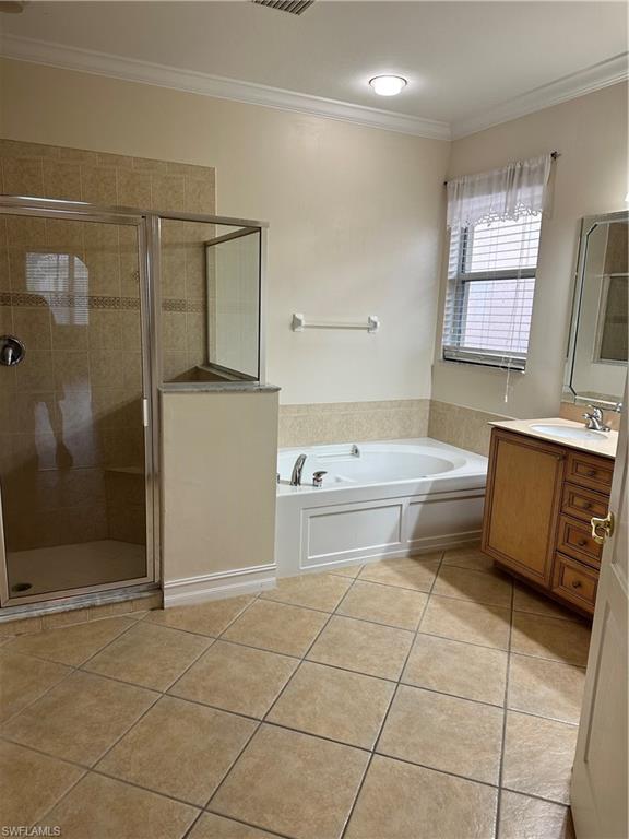 8267 Laurel Lakes Way Naples, FL 34119 - Photo 18 of 23 Full bathroom with ornamental molding, a bath, light tile patterned flooring, a stall shower, and vanity