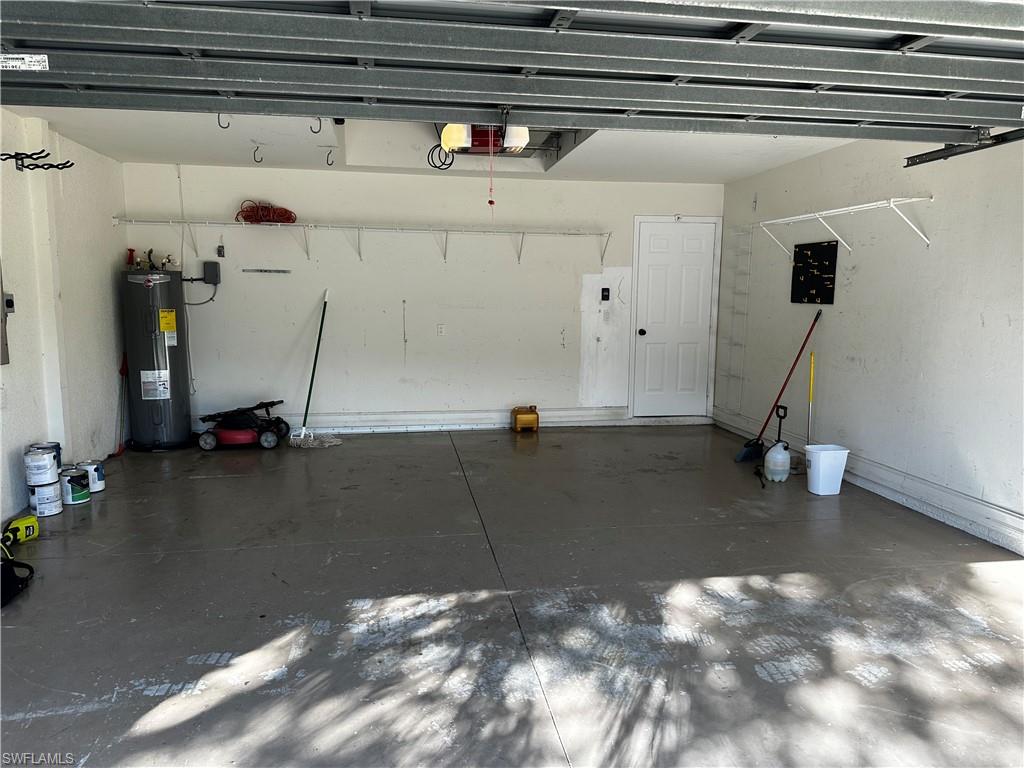 8267 Laurel Lakes Way Naples, FL 34119 - Photo 20 of 23 Garage featuring electric water heater and a garage door opener