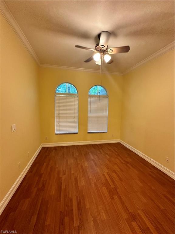 8267 Laurel Lakes Way Naples, FL 34119 - Photo 8 of 23 Spare room with crown molding, dark wood-style flooring, a textured ceiling, and ceiling fan