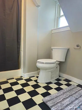 a bathroom with a black and white checkered floor