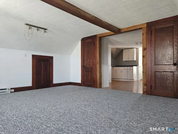 a view of empty room with cabinet and refrigerator