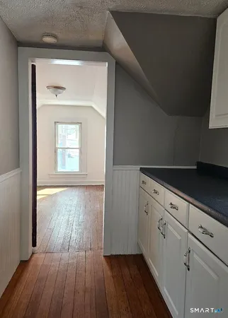 a view of a hallway with wooden floor and a window