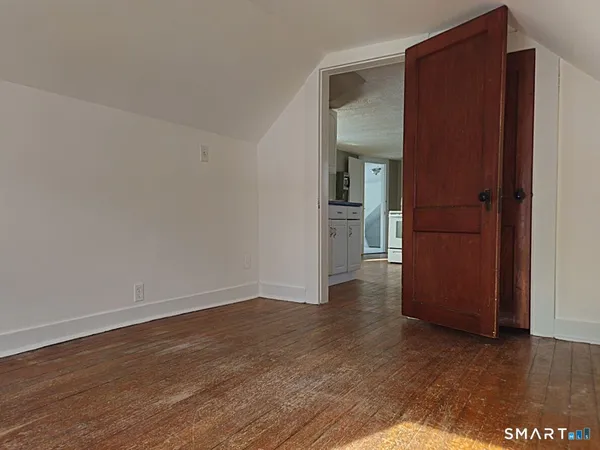 a view of a hallway with wooden floor and closet