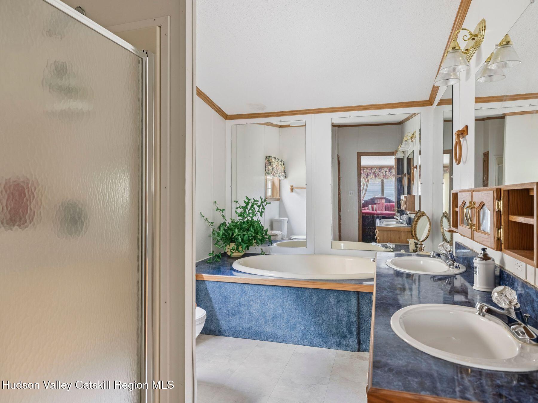 370 Begley Road Windham, NY 12496 - Photo 30 of 51 a bathroom with a granite countertop sink a mirror and a bathtub