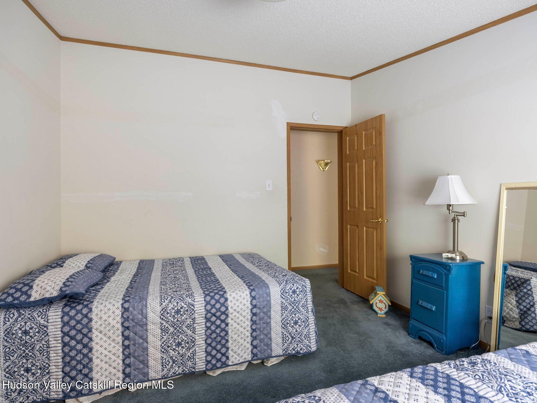 370 Begley Road Windham, NY 12496 - Photo 32 of 51 a bedroom with a bed and a lamp on table