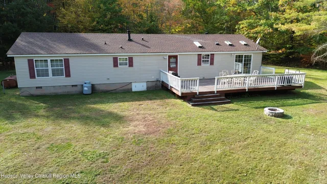 an aerial view of a house with swimming pool and wooden bench