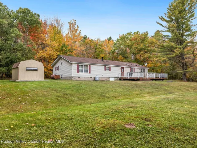 a view of a house with a backyard and a patio