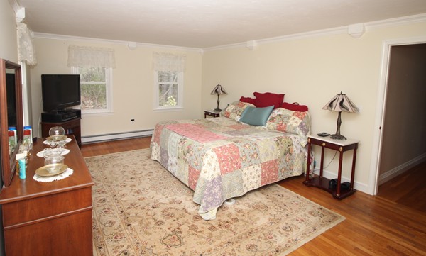 4 Lyn Path Hopkinton, MA 01748 - Photo 18 of 28 a bedroom with a bed and wooden floor