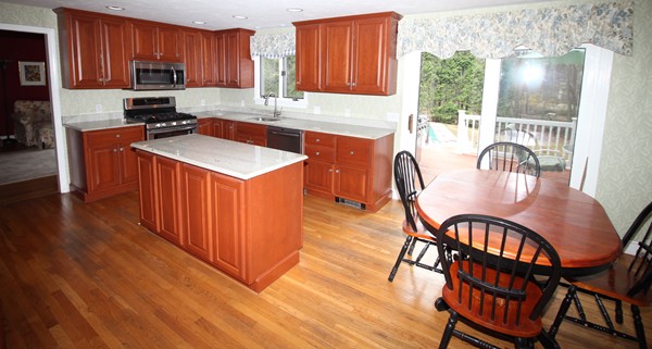 4 Lyn Path Hopkinton, MA 01748 - Photo 10 of 28 a kitchen with stainless steel appliances granite countertop a stove top oven a sink dishwasher a dining table and chairs with wooden floor