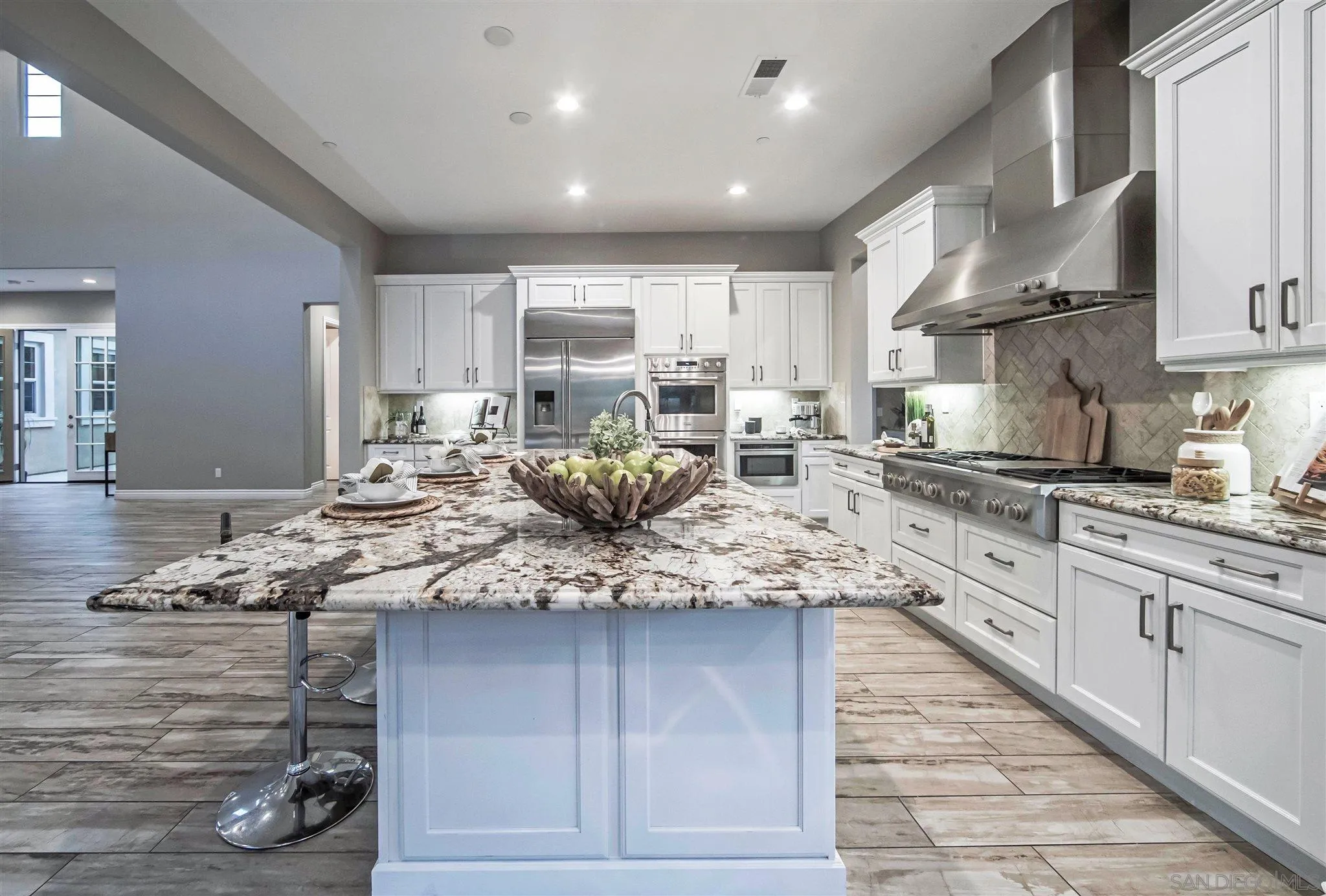 545 Ledge Street San Marcos, CA 92078 - Photo 14 of 55 a kitchen with kitchen island granite countertop wooden cabinets and white appliances