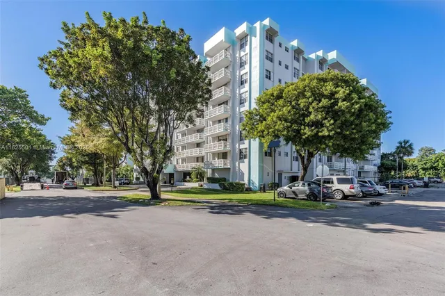a front view of multi story residential apartment building with trees