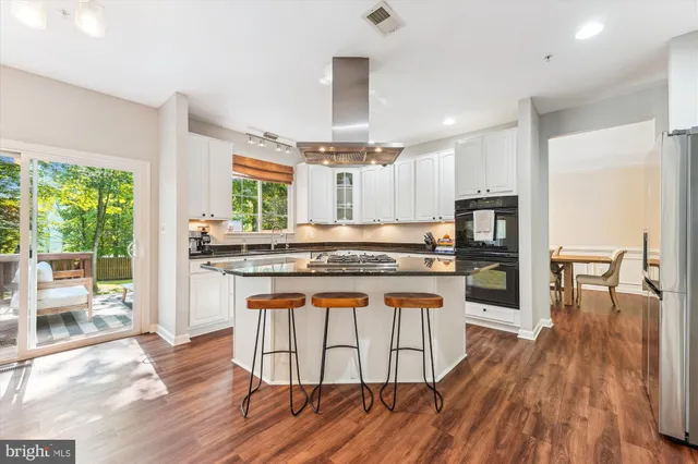 a kitchen with stainless steel appliances kitchen island granite countertop a stove and a sink