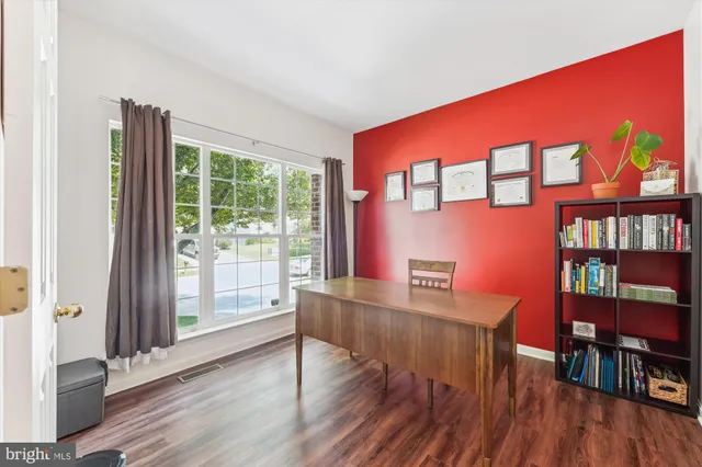 a spacious bedroom with a bed and wooden floor