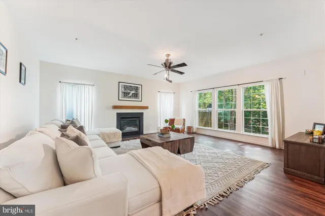 a living room with fireplace furniture and a large window