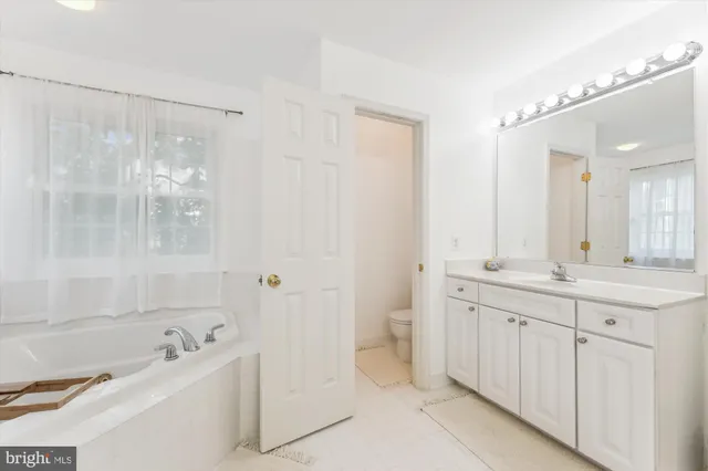 a bedroom with a bed and a large mirror with a window