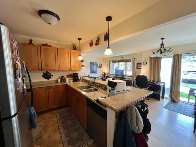 a open kitchen with stainless steel appliances granite countertop a sink a stove and refrigerator