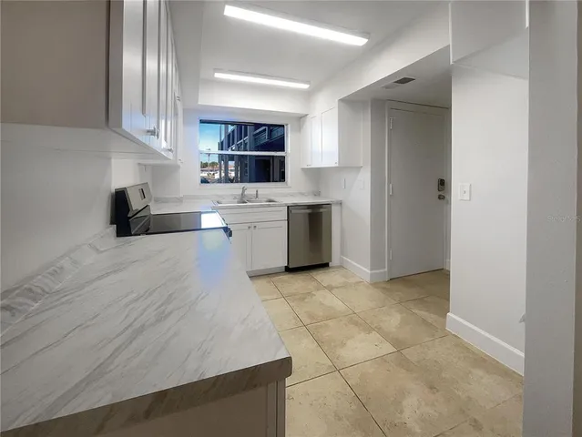 a large kitchen with a stove a sink dishwasher and a refrigerator