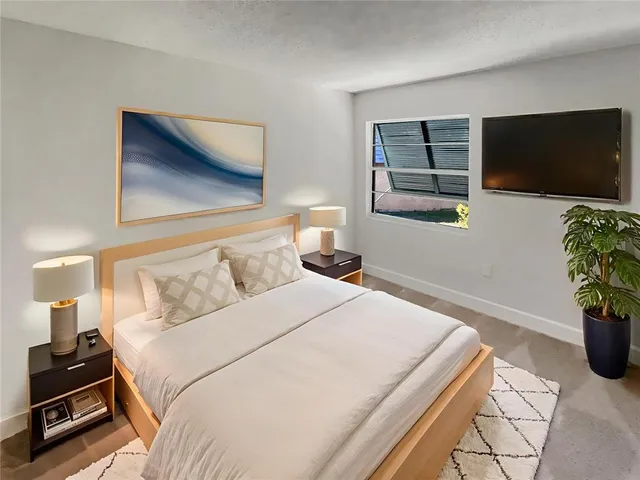 a bedroom with a bed and a flat screen tv