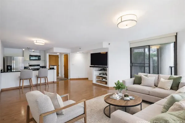 a living room with furniture kitchen view and a large window