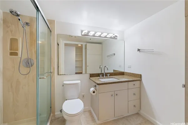 a bathroom with a granite countertop sink toilet and shower