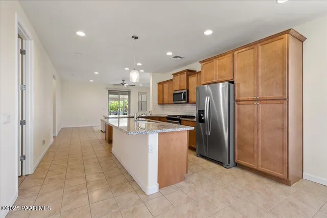 a large kitchen with a refrigerator and a stove