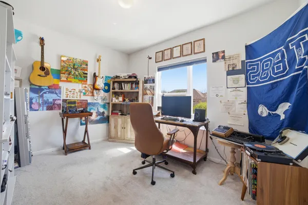 a living room with stainless steel appliances furniture a refrigerator a kitchen island a stove and a sink