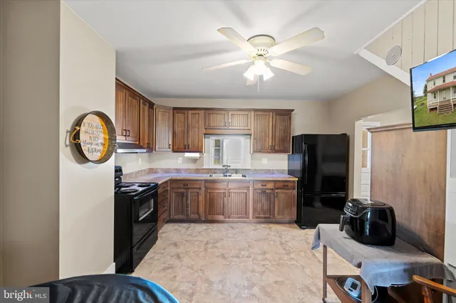 a kitchen with stainless steel appliances granite countertop a stove refrigerator a sink dishwasher with a dining table and chairs