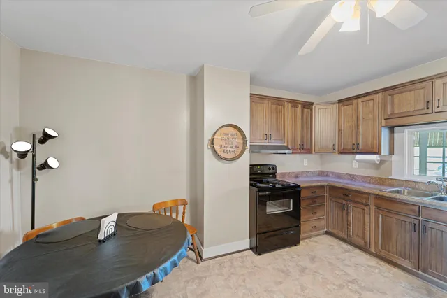 a kitchen with granite countertop a sink cabinets and stainless steel appliances