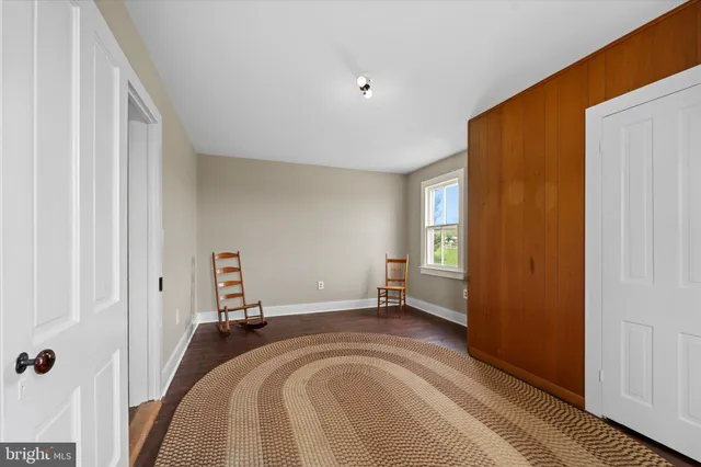 a view of a bedroom with wooden floor and bathroom