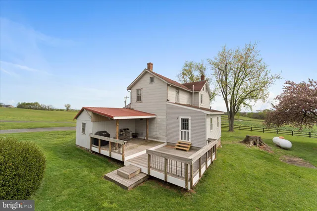 a view of a house with a big yard and large trees