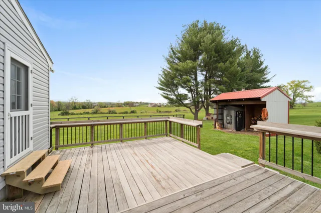 a view of a deck with wooden floor and fence with a large garden