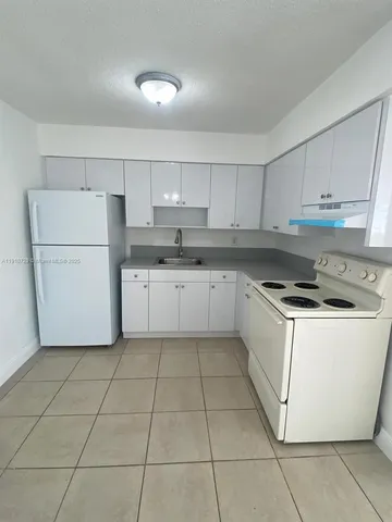 a kitchen with cabinets and white appliances