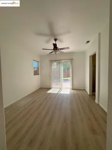 an empty room with wooden floor and fireplace