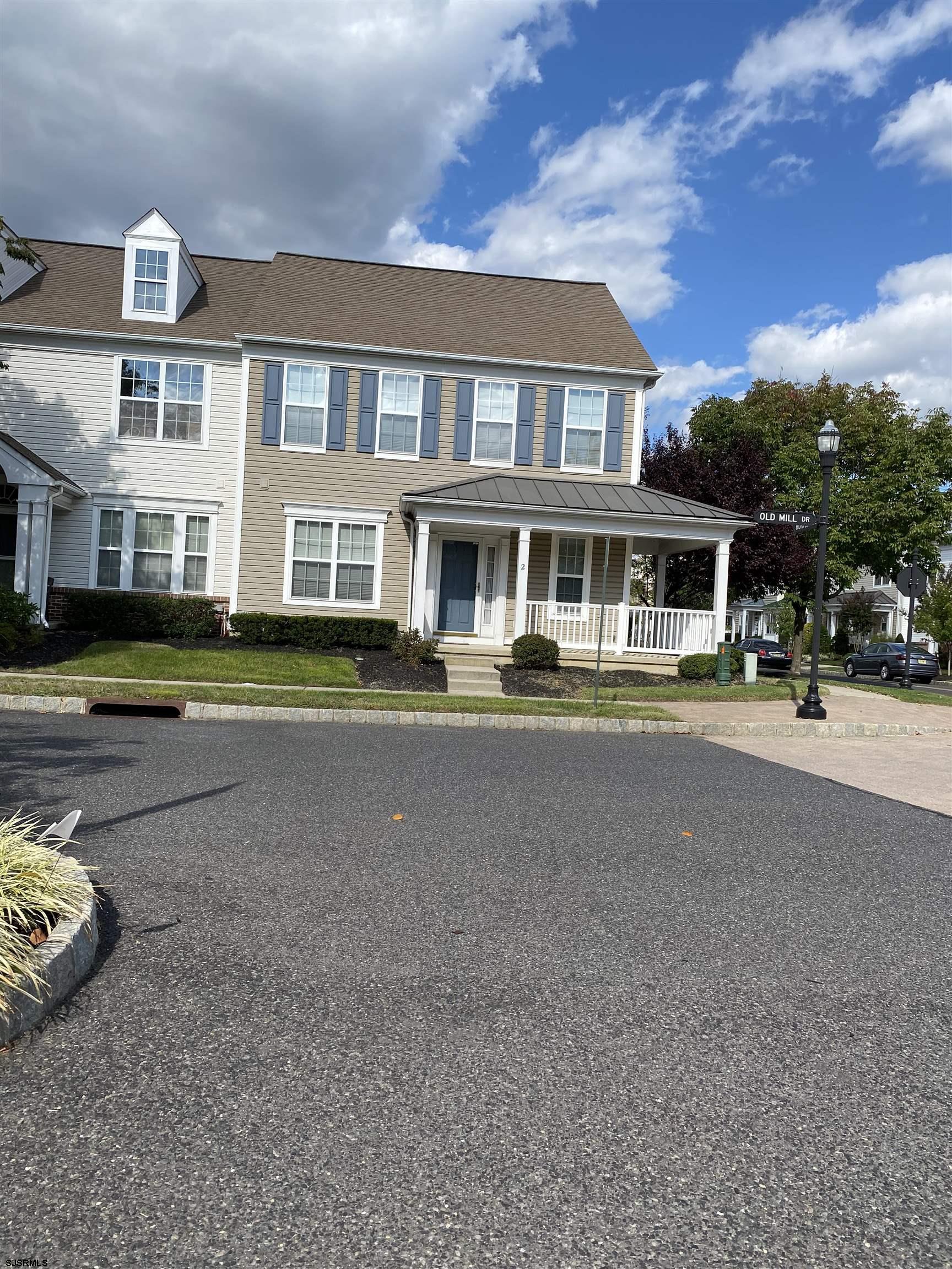 a front view of a house with a garden and lake view