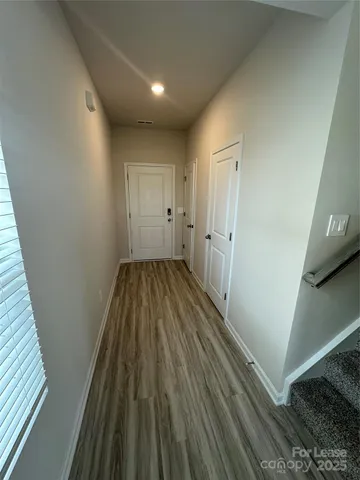 a view of a hallway with wooden floor and staircase