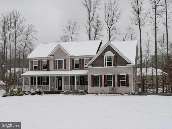 a front view of a house with a yard covered in snow