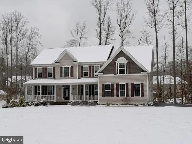 a front view of a house with a yard covered in snow