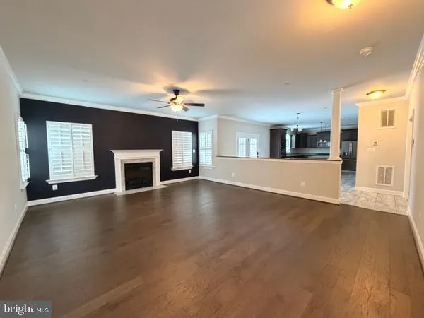 an empty room with windows and fireplace