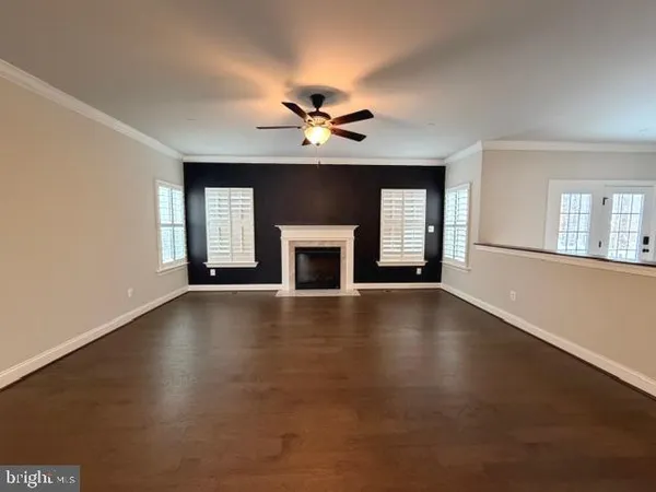 an empty room with windows and fireplace