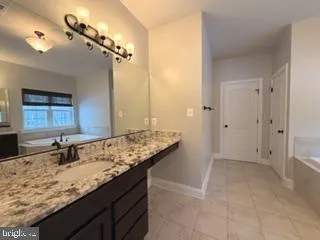 a bathroom with a granite countertop sink a mirror and shower