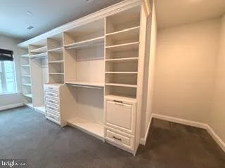 a view of an empty room with cabinet and a window