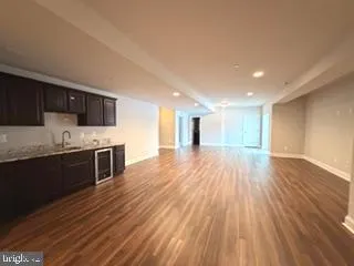 a large kitchen with stainless steel appliances granite countertop a large counter top a stove and a wooden floors