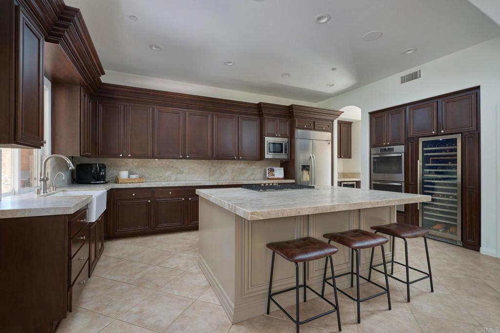 835 Stratford Knoll Encinitas, CA 92024 - Photo 14 of 31 a kitchen with a table chairs refrigerator and cabinets