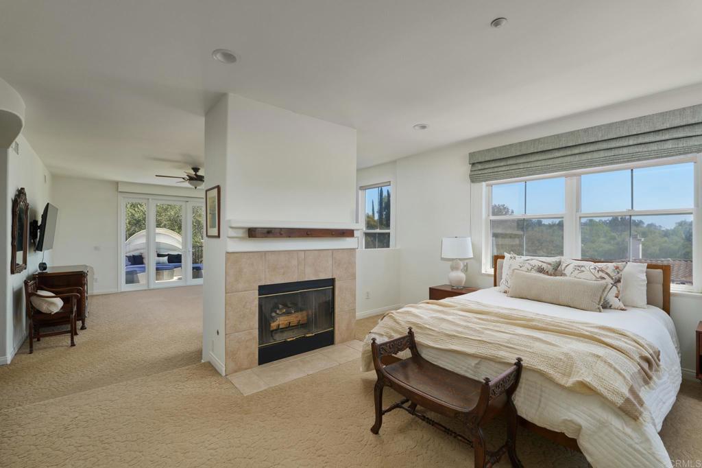 835 Stratford Knoll Encinitas, CA 92024 - Photo 17 of 31 a bedroom with a bed and a fireplace