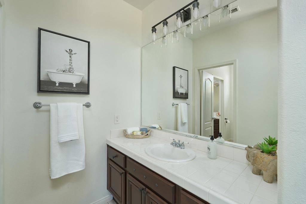 835 Stratford Knoll Encinitas, CA 92024 - Photo 24 of 31 a bathroom with a double vanity sink and a mirror