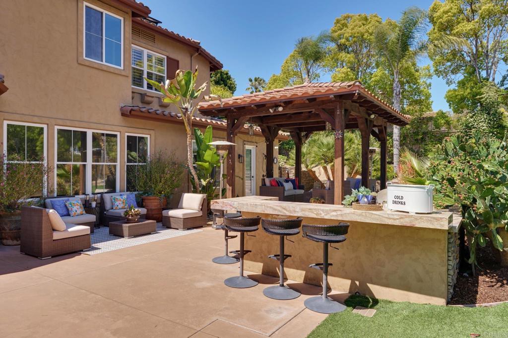 835 Stratford Knoll Encinitas, CA 92024 - Photo 5 of 31 a view of a patio with table and chairs potted plants and a palm tree