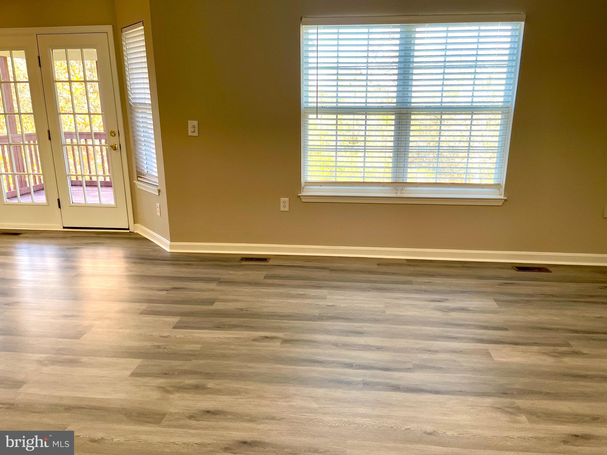 12003 Piscataway Road Clinton, MD 20735 - Photo 13 of 68 a view of an empty room with wooden floor and a window