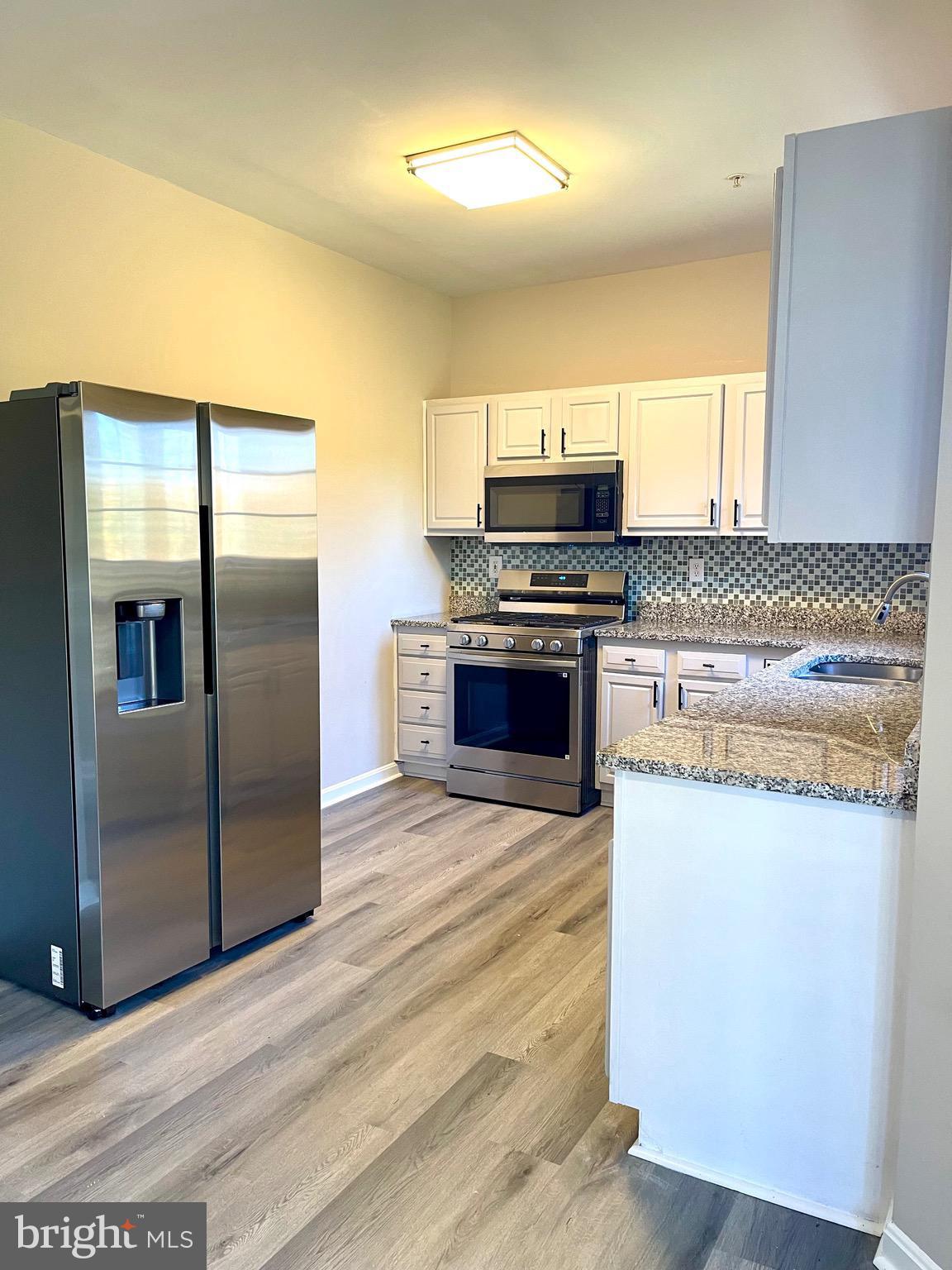 12003 Piscataway Road Clinton, MD 20735 - Photo 17 of 68 a kitchen with stainless steel appliances granite countertop a stove a refrigerator and a sink