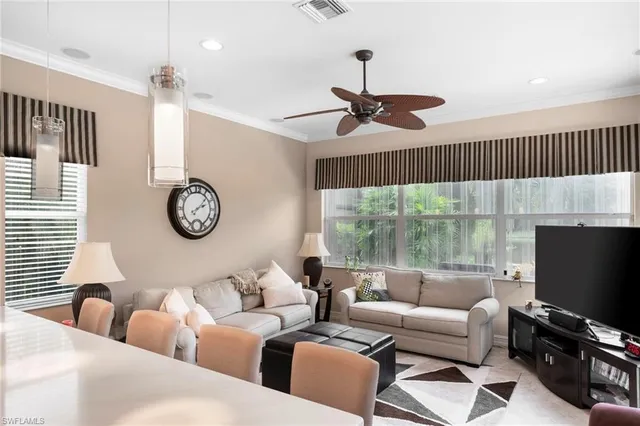 a living room with furniture a ceiling fan and a window