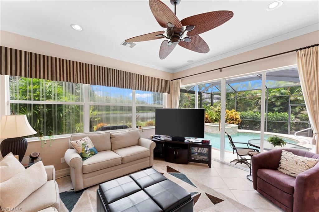 6155 Dogleg Drive Naples, FL 34113 - Photo 24 of 36 a living room with furniture floor to ceiling window and a flat screen tv
